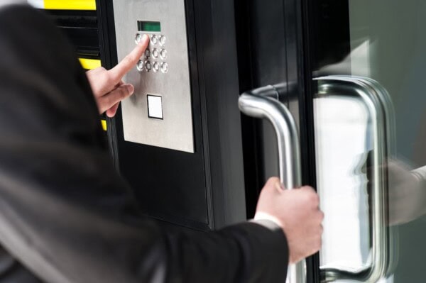 businessman entering safe code to unlock the door.
