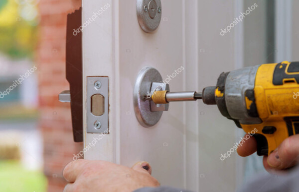 handyman repair the door lock in the worker's hands installing new door locker