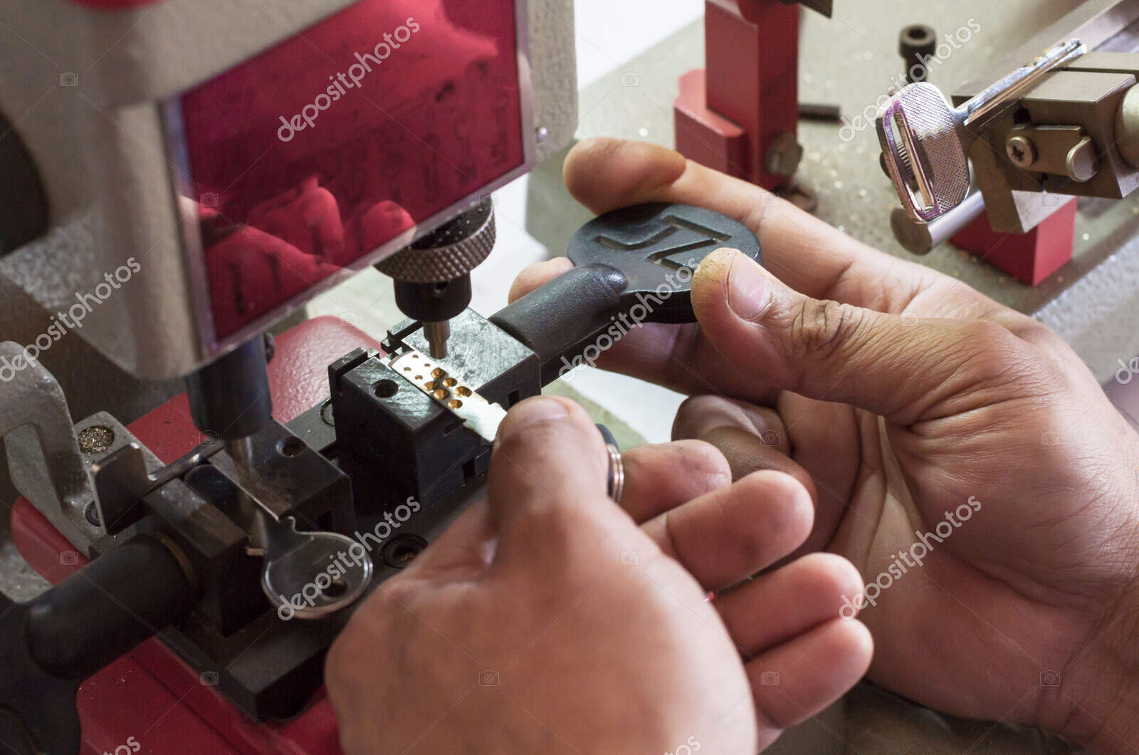 locksmith in workshop makes new key. professional making key in
