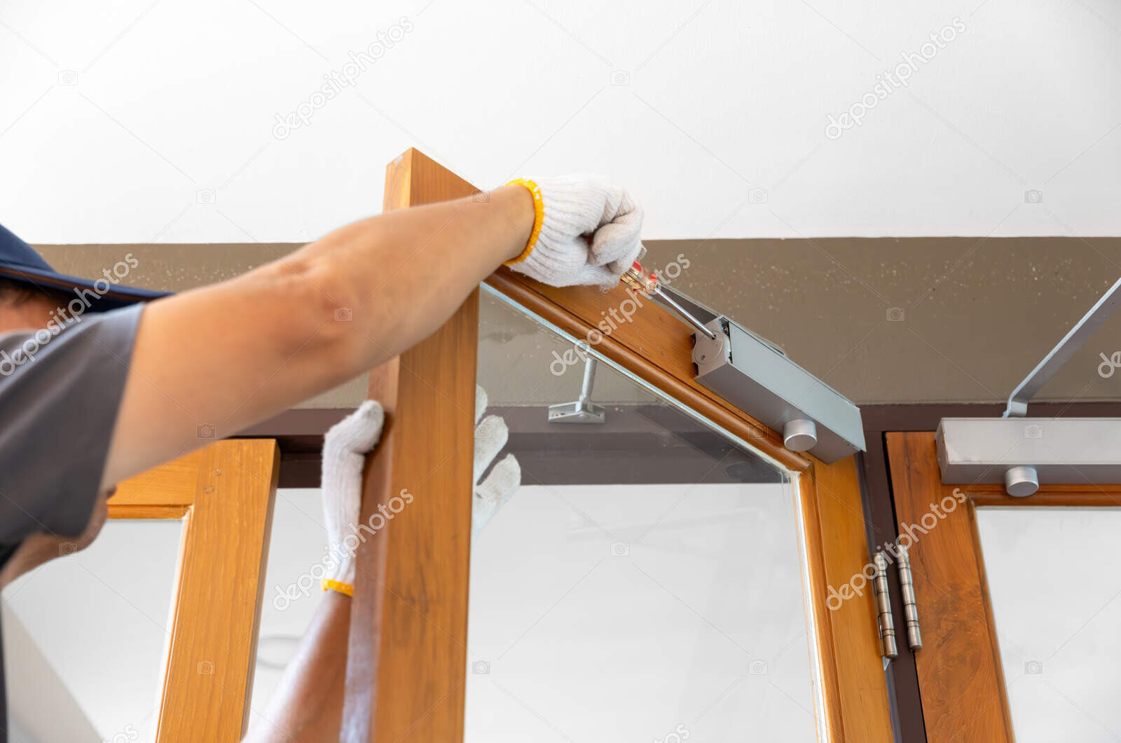 depositphotos 737147478 stock photo handyman fixing door closer adjust